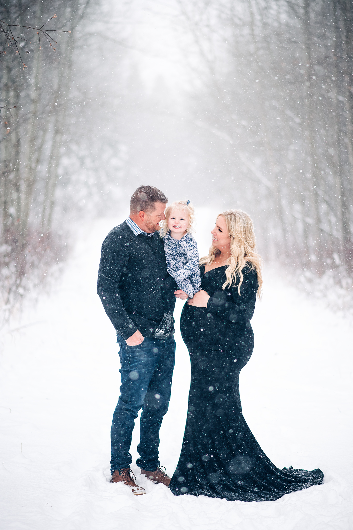 family of three smiling winter maternity session expecting parents strathcona county alberta