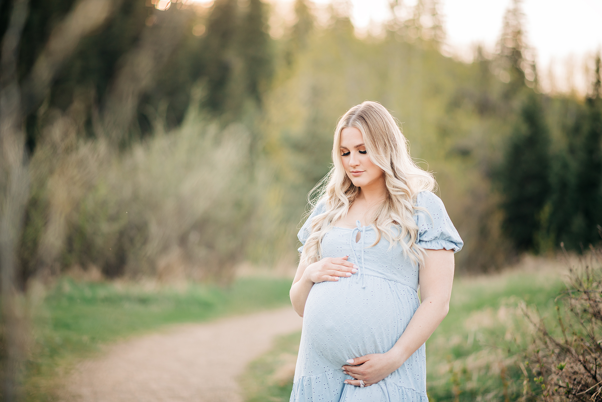 expectant mother embraces baby bump golden hour maternity photo session yeg