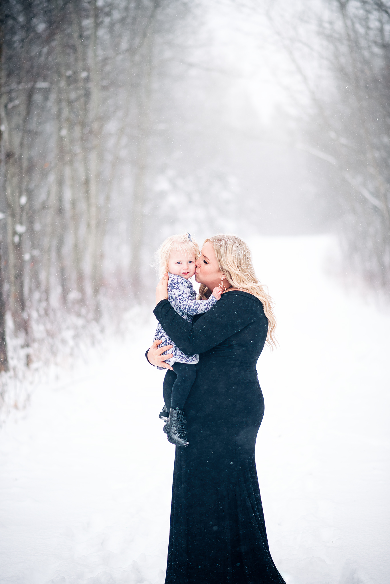 expecting mother kissing toddler daughter winter maternity photo session strathcona county ab