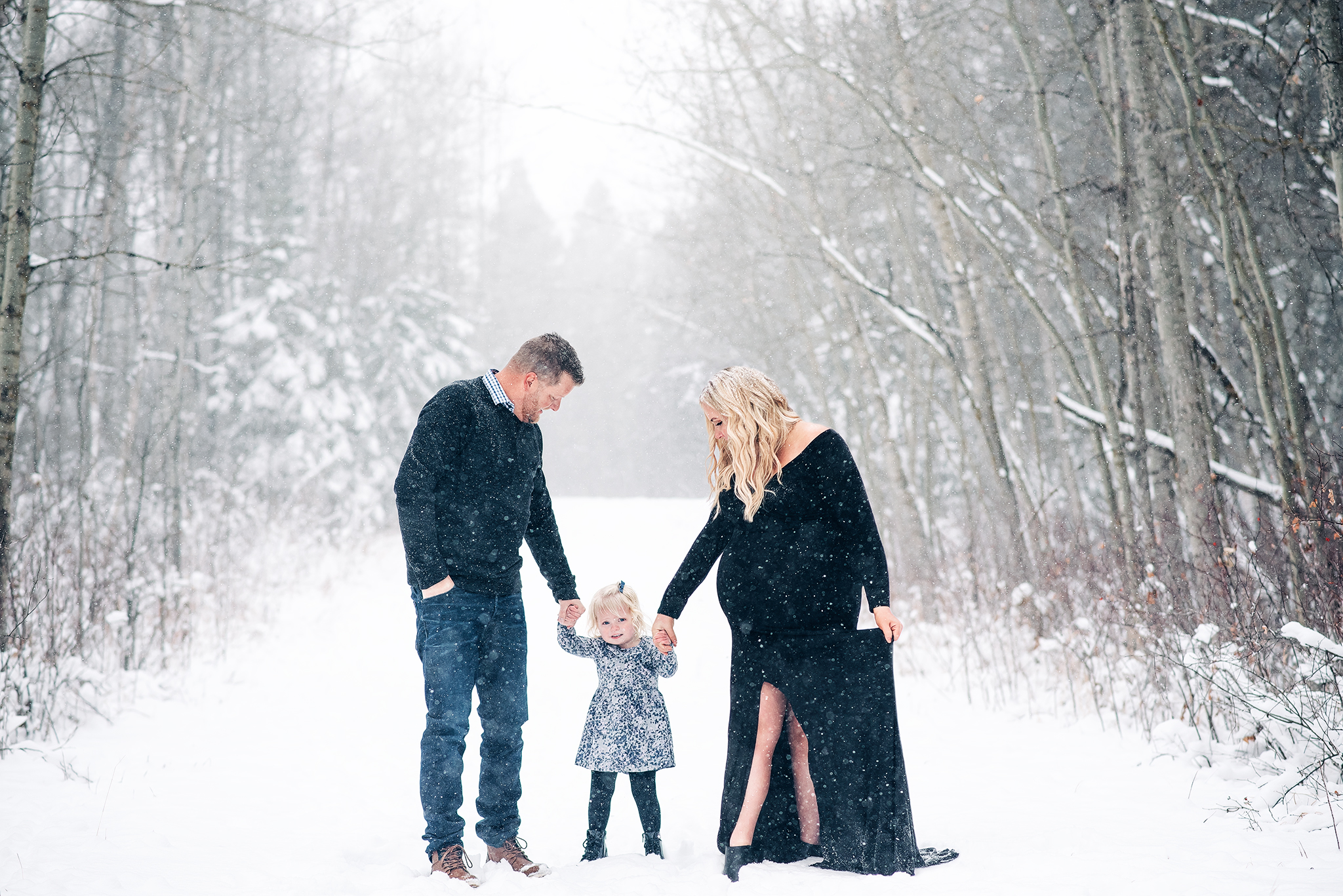 family of three walking snowy path winter maternity session expecting parents strathcona county alberta