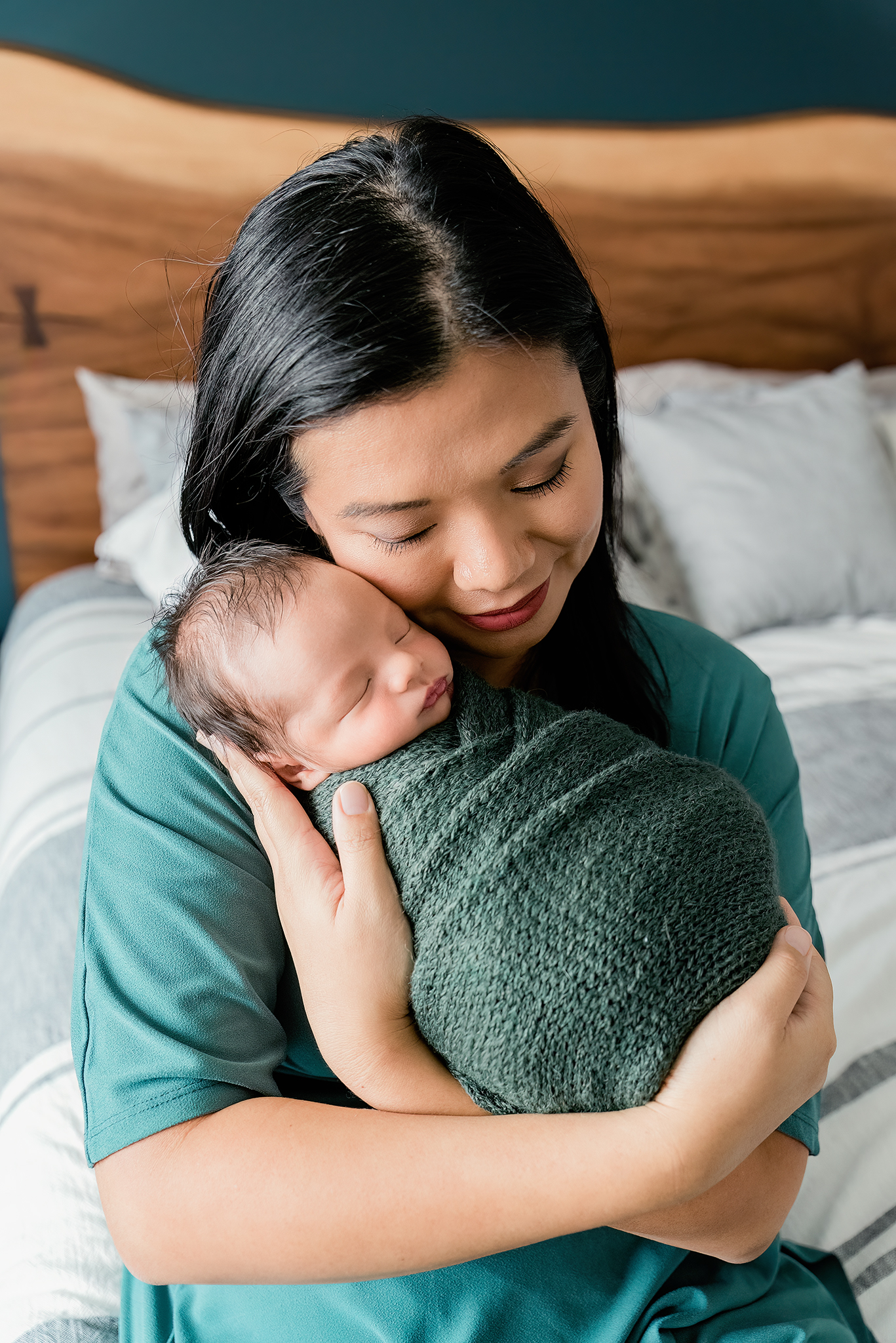 mom holds infant son close to her face smiling in home newborn photography session sherwood park alberta