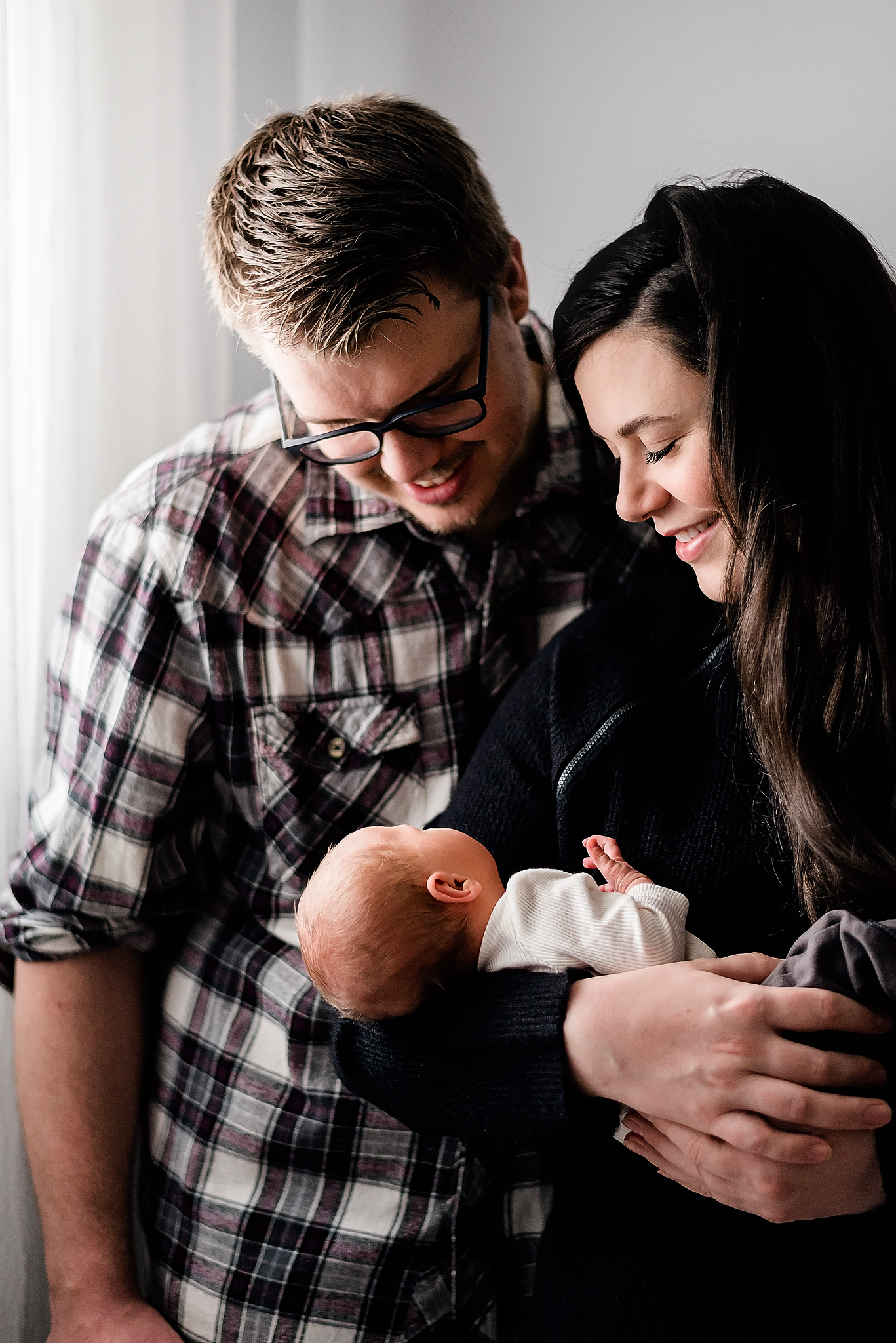mom and dad smile at newborn baby girl lifestyle newborn photo session ft sask